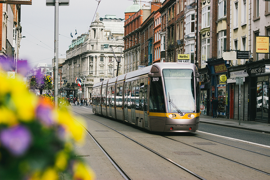 An electric tram travelling through a street in Dublin, Ireland.