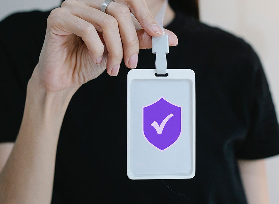 Woman's hand holding a secure access badge on a lanyard