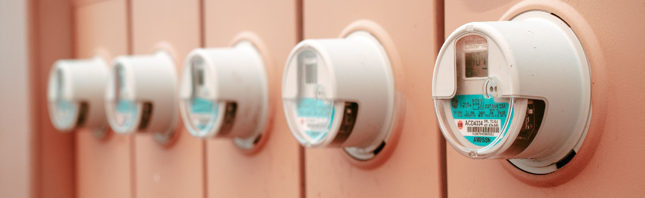 A line of energy meters mounted on a wall.