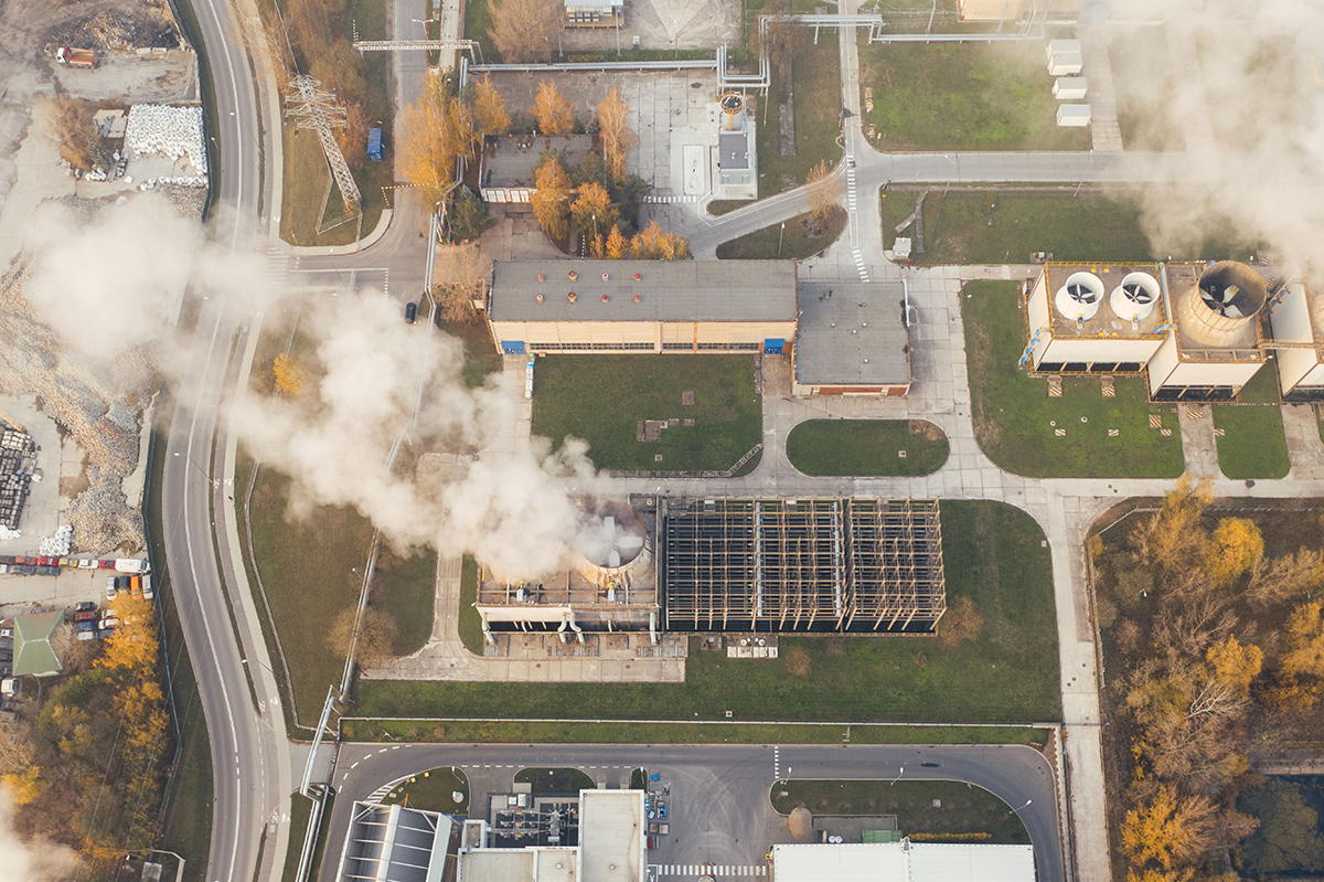 Large cooling towers venting steam from an industrial campus.