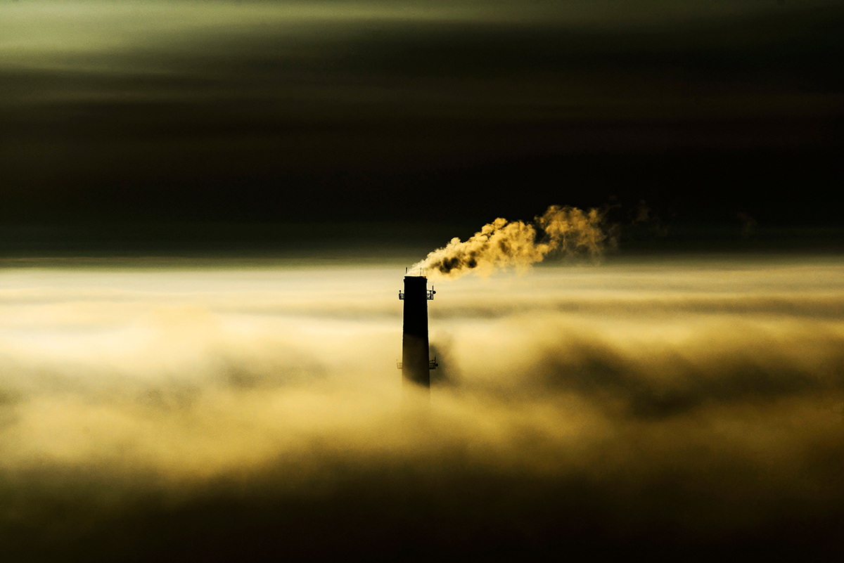 Cooling tower venting steam in the midst of a haze of fog