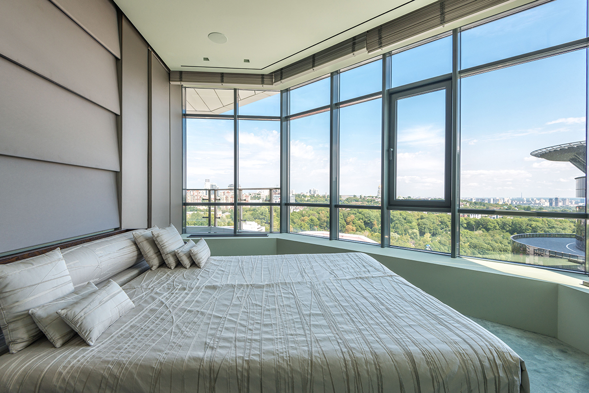 A hotel room with a large window filling it with daylight.